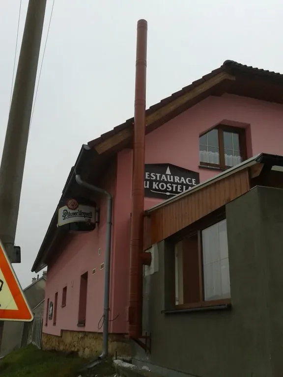 Nerezový komín vedený po fasádě
